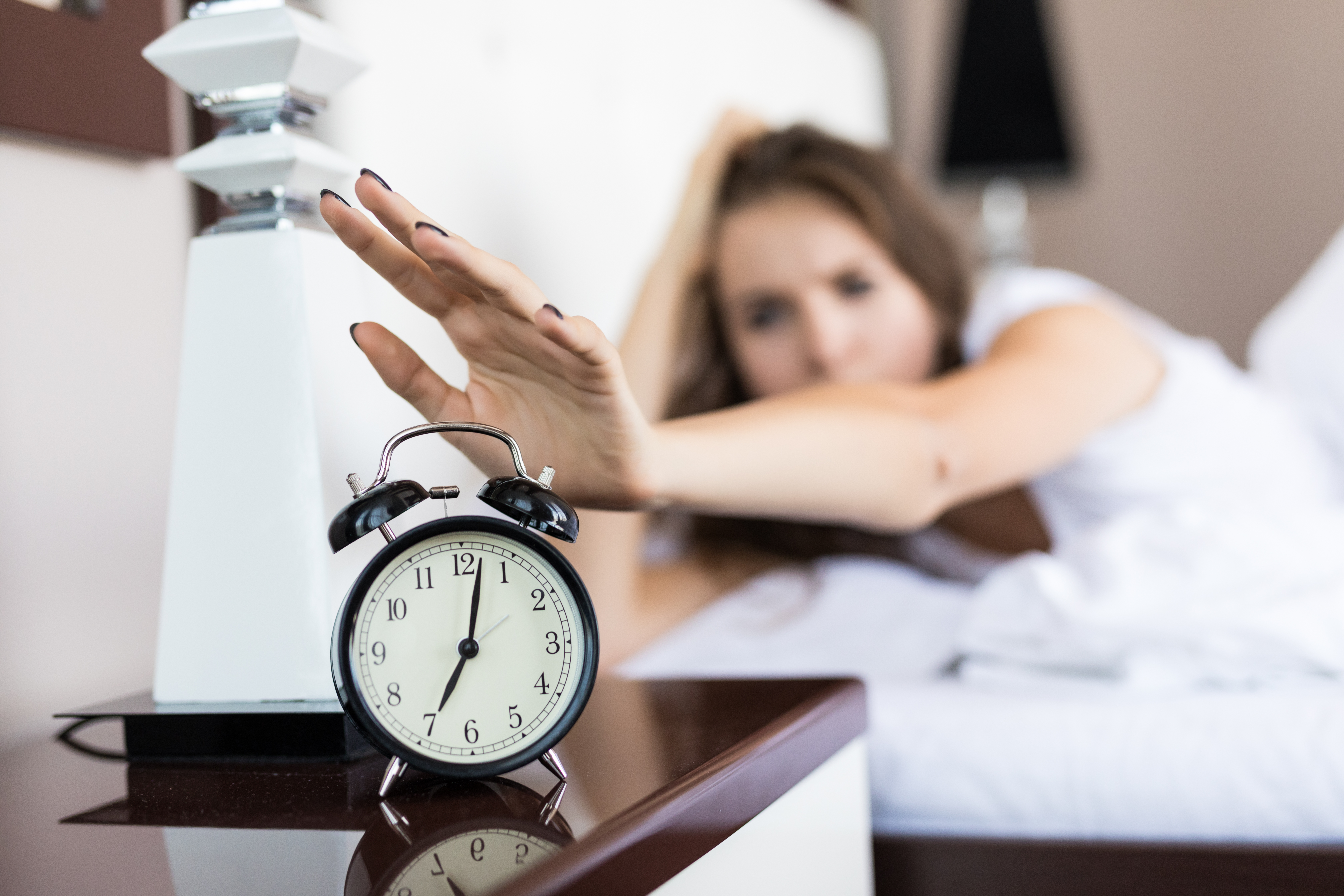 Künstlich, emotional, oft unheimlich? Wie KI-Spots statt Stirnrunzeln Sympathie auslösen – eine Top-3 mit Best-Practice Eine Frau, die einem futuristischen Menschen ähnlichem Hologramm gegenübersteht, getrennt durch eine Glasscheibe, in einem modernen, beleuchteten Innenraum.