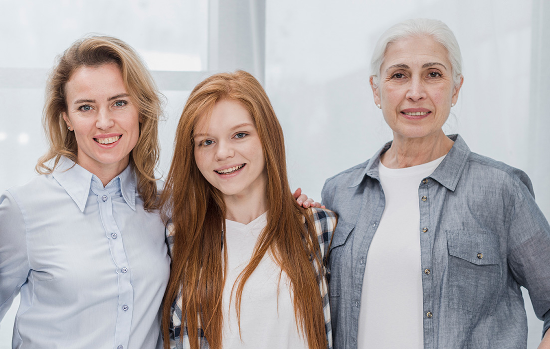 Drei Frauen verschiedener Generationen lächeln in die Kamera