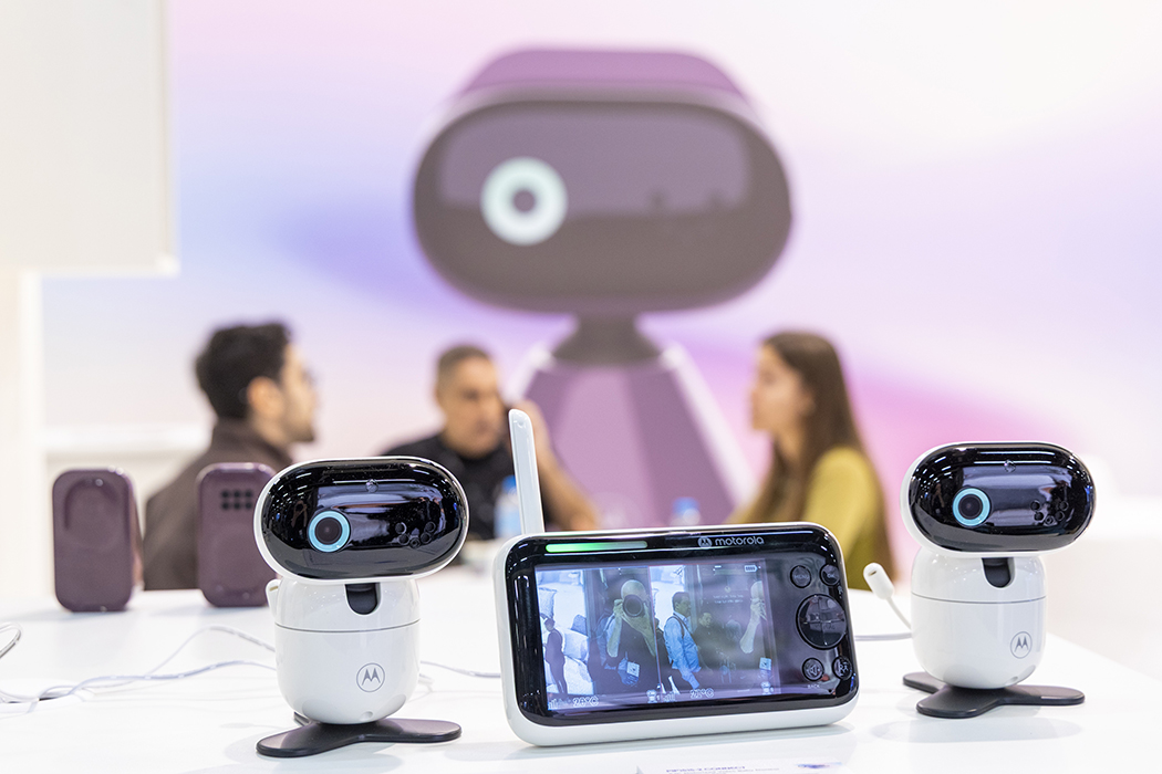 Babyphone im Vordergrund, mit Menschen im Hintergrund