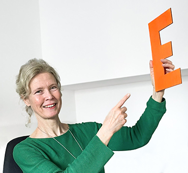 Person mit einem gebastelten Buchstaben E aus Pappe in einer Hand..