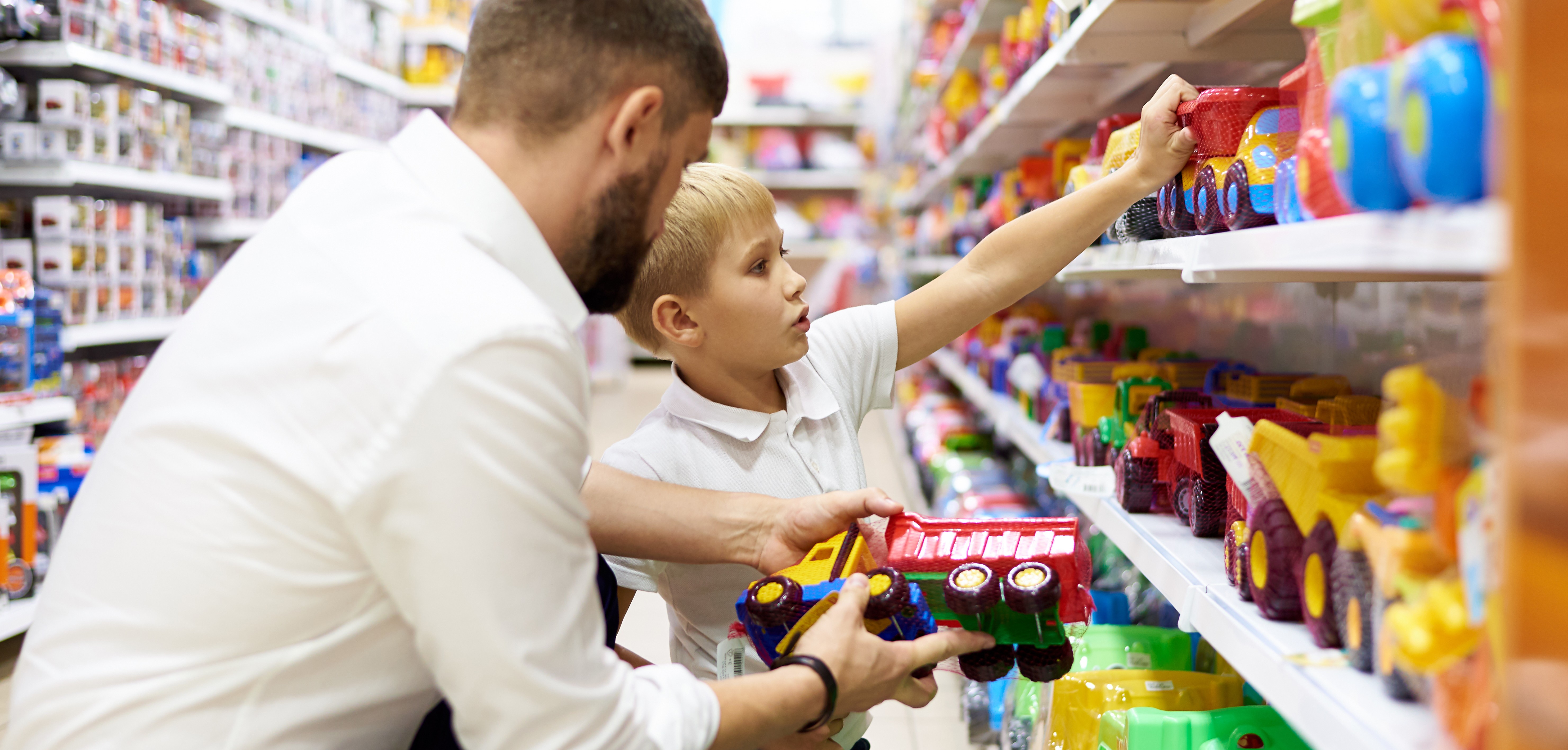 Vater und Sohn mit Spielzeug im Supermarkt