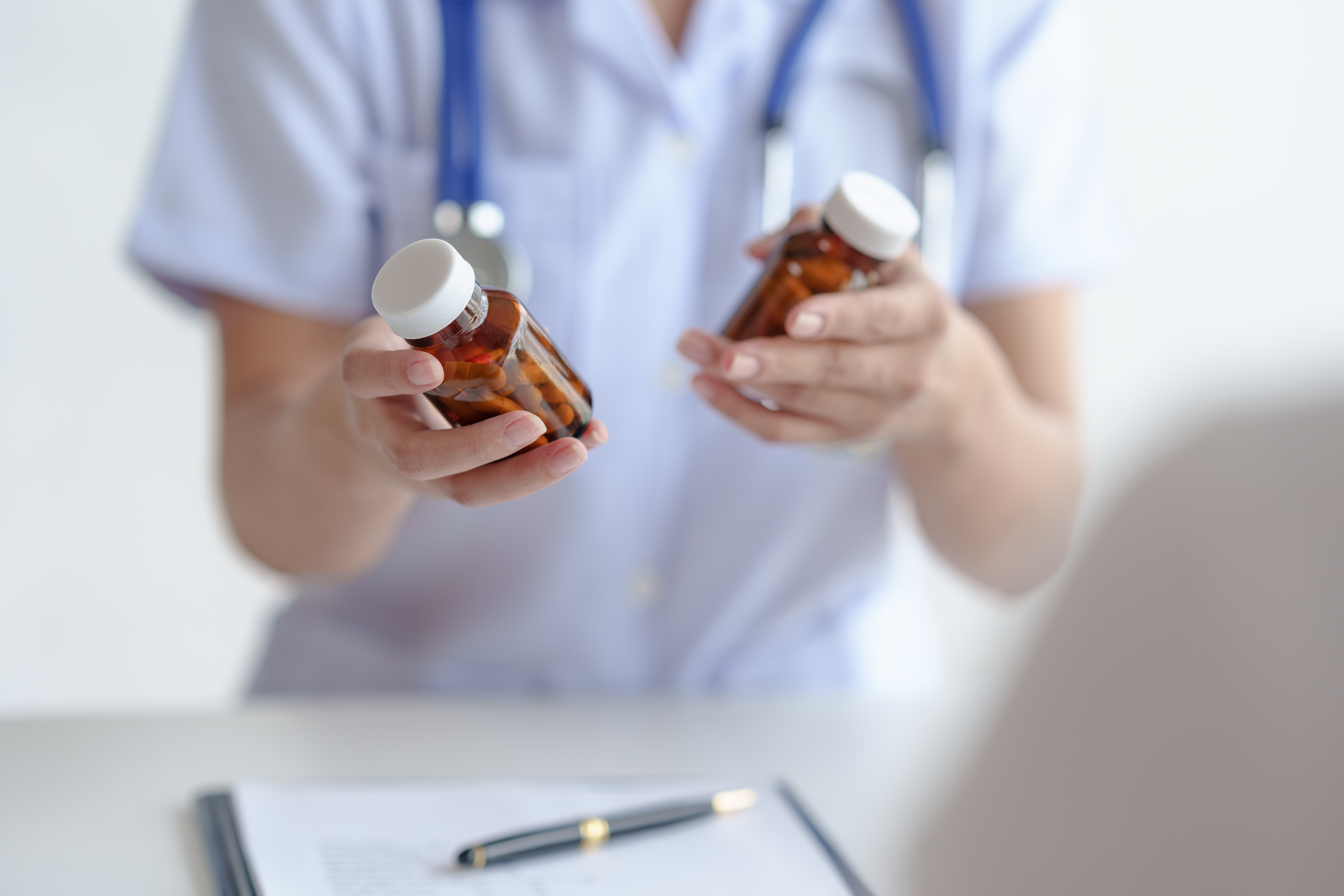 Ein Arzt mit Tablet in der Hand im Gespräch mit einem Patienten im Gesundheitswesen.
