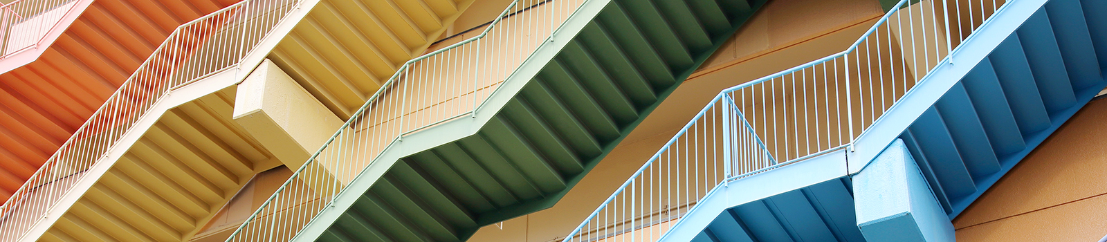 Bunte Treppen mit der selben Verlaufsrichtung in unterschiedlichen Stockwerken.