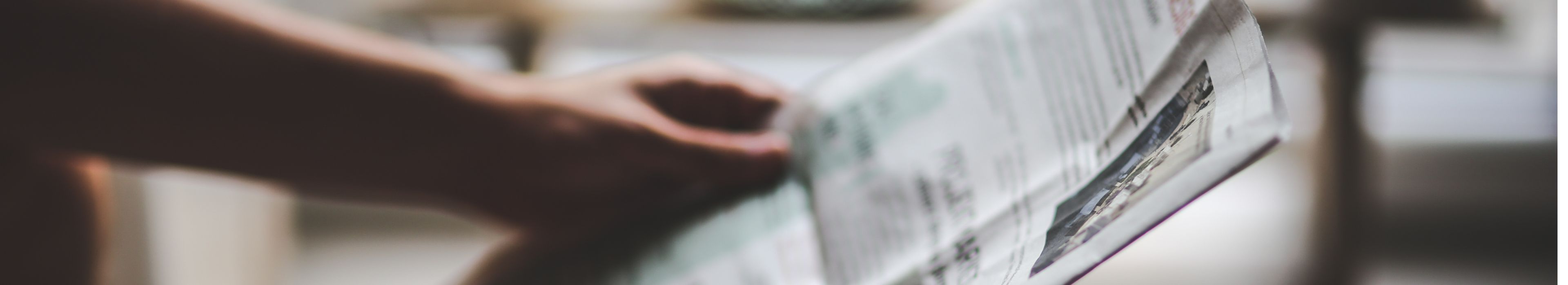 Eine Hand die eine Zeitung hält.