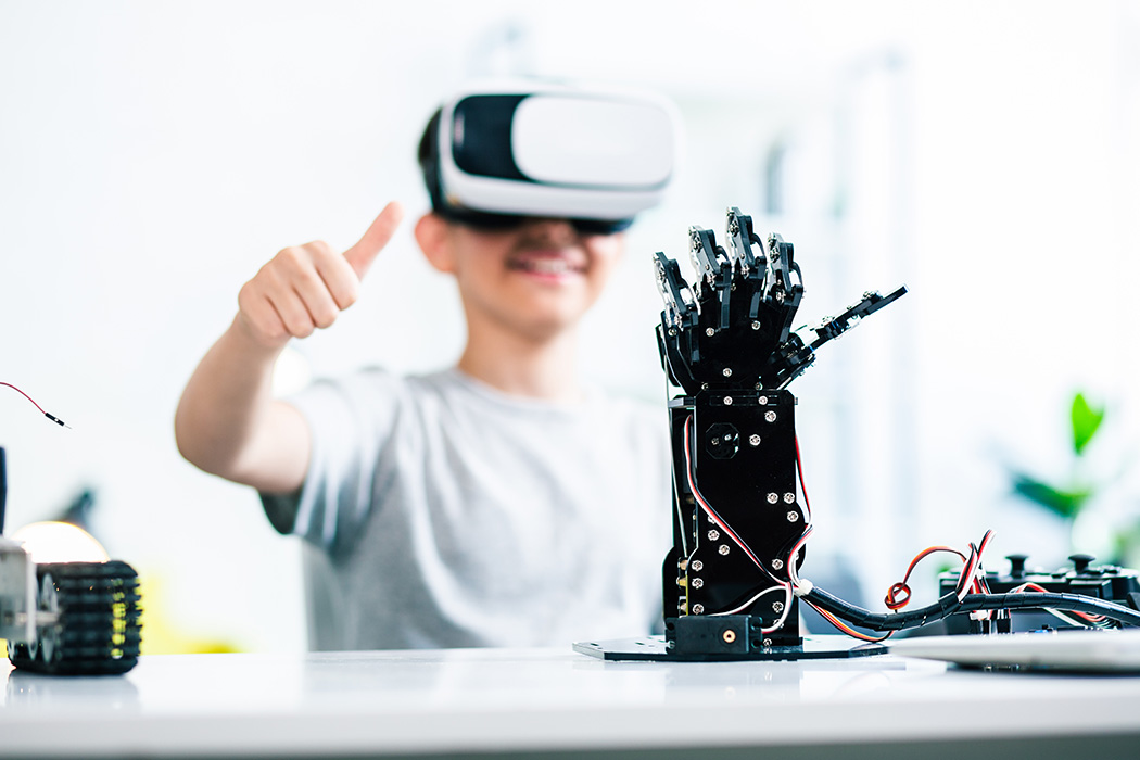Junge-mit-VR-Brille-auf-steuert-eine-Roboterhand