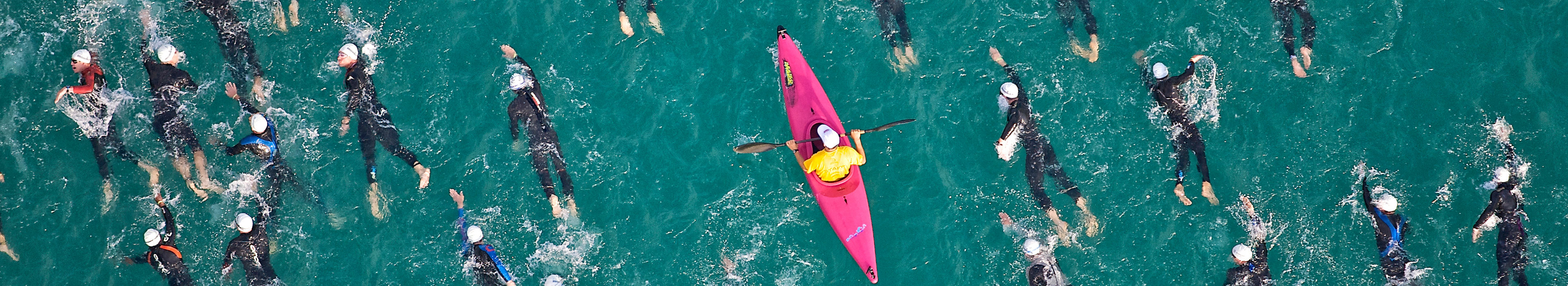 Ein Schwimmtrainer unterstützt seine Athleten auf dem Wasser